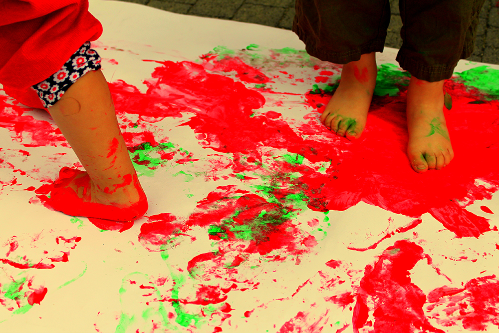 Kinder malen mit ihren Füßen