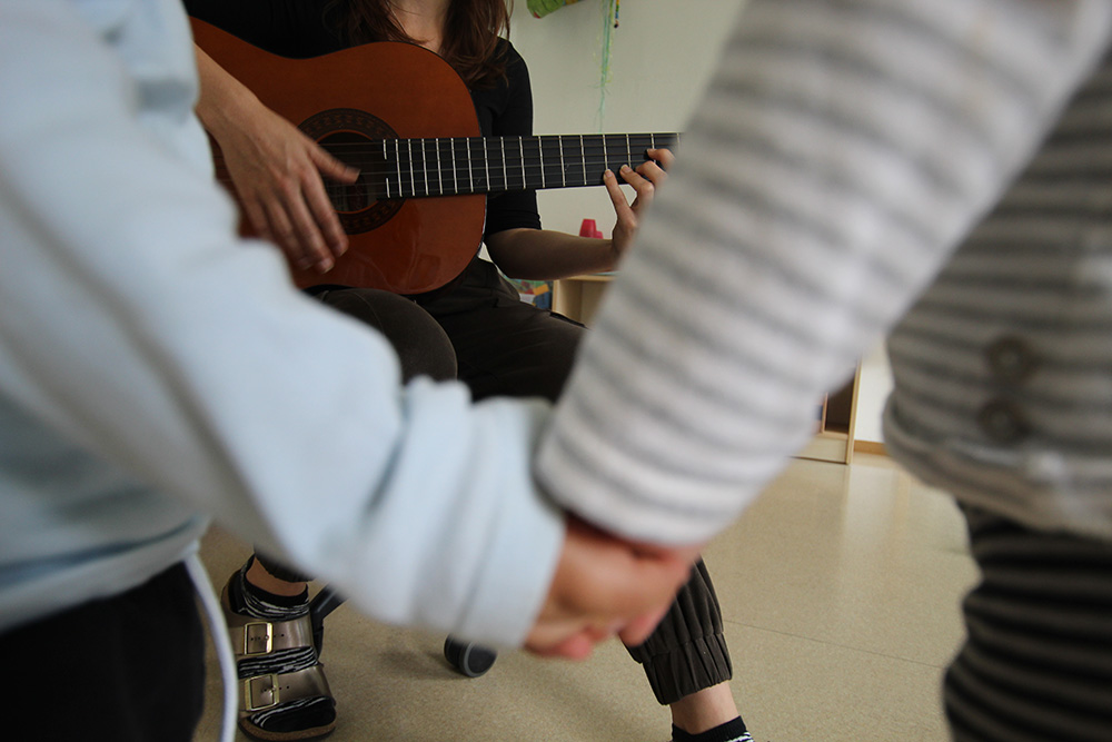 Guitar playing and kids holding hands